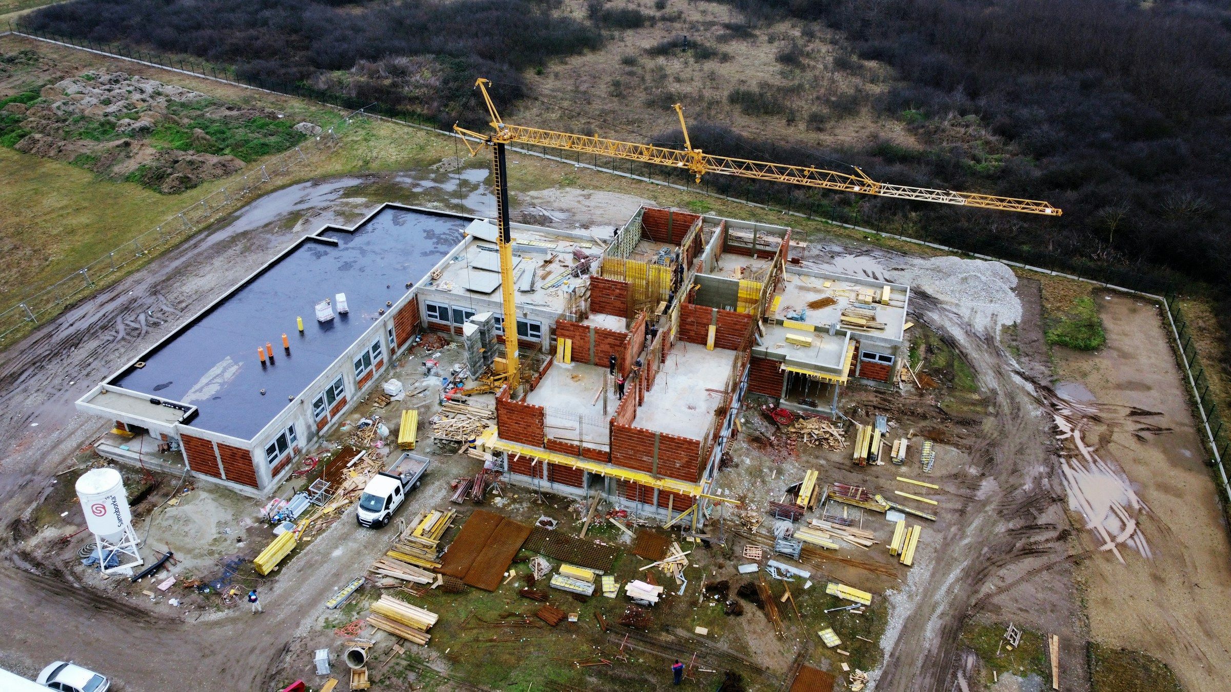 Rohbau mit Kran auf einer Baustelle aus der Luft