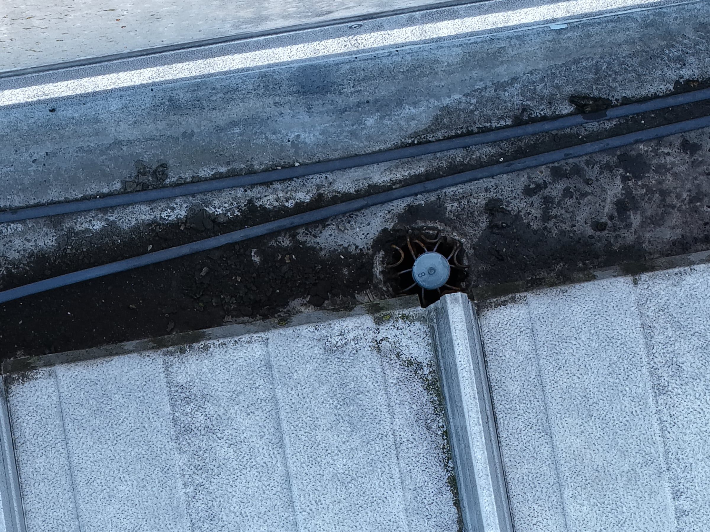 Verschmutzte Kastenrinne mit Dachablauf auf einem Industriedach