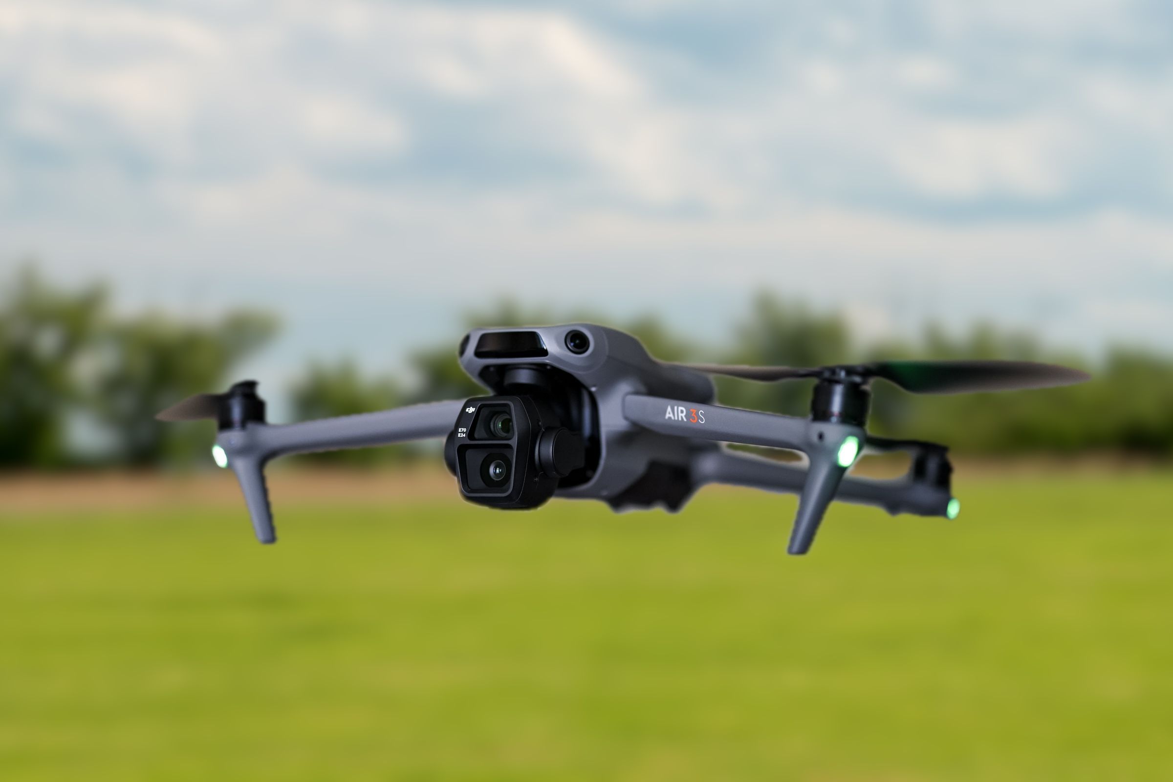 DJI Air 3S im Flug über einer Wiese