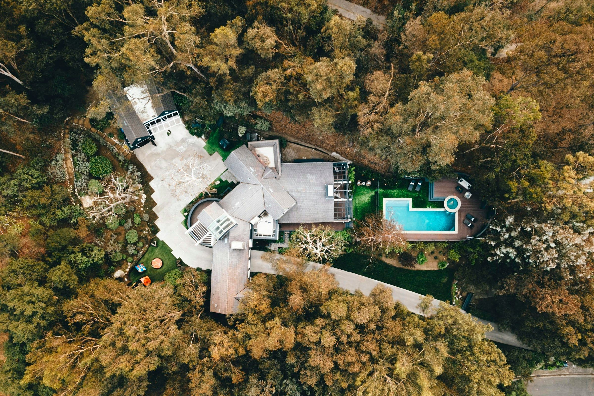 Modernes Haus mit Pool, von Bäumen umgeben, von oben
